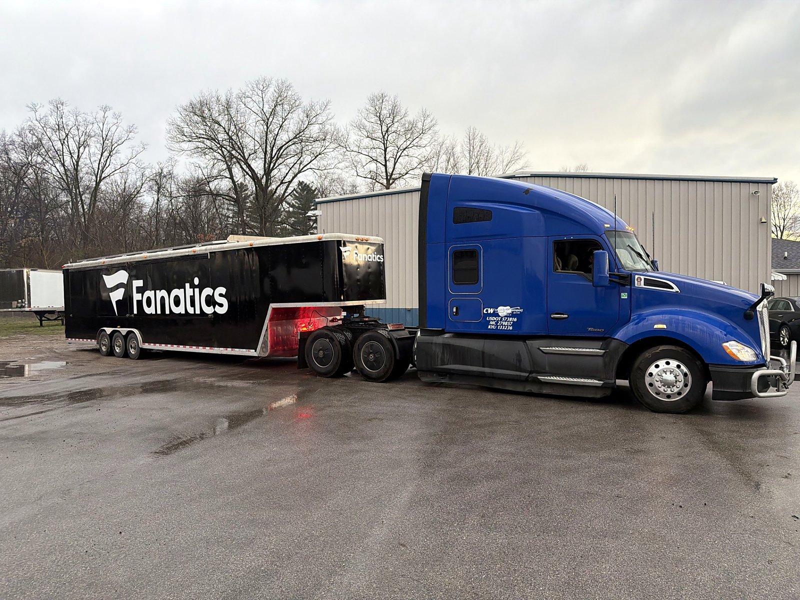 A merchandise trailer hooked to a blue CW Kenworth